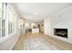 Bright, open living space with refinished floors, a fireplace, and a seamless transition to a modern kitchen at 1964 Wellington Rd, Burlington, NC 27217