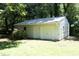 Detached outbuilding with white siding and double doors, ideal for a workshop or extra storage space at 1964 Wellington Rd, Burlington, NC 27217