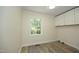 Versatile room with wood-look flooring, a bright window, and overhead storage cabinets at 1964 Wellington Rd, Burlington, NC 27217