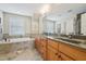 Bright bathroom featuring a large tub, double sink vanity, and neutral paint at 1985 Firenza Dr, Apex, NC 27502