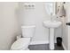 Clean bathroom with a modern pedestal sink, toilet, and decorative wall accents at 1985 Firenza Dr, Apex, NC 27502
