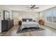 Bright bedroom featuring wood floors, a ceiling fan, neutral paint, and well-lit sitting area at 1985 Firenza Dr, Apex, NC 27502