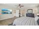 View of bedroom with ceiling fan, television, and entry to another room and hallway at 1985 Firenza Dr, Apex, NC 27502