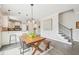 Open-concept kitchen featuring granite countertops, bar seating, and a view of the staircase at 1985 Firenza Dr, Apex, NC 27502