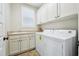 Practical laundry room equipped with a sink, storage cabinets, and modern washer and dryer units at 1985 Firenza Dr, Apex, NC 27502