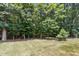 Backyard with grass and trees at 203 Pathwood Ln, Durham, NC 27705