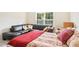 Cozy bedroom with a plush bed, black leather couch, bright window, and stylish decorative pillows at 203 Pathwood Ln, Durham, NC 27705