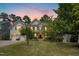 Charming home with manicured front lawn, mature trees, and an attached two-car garage at 203 Pathwood Ln, Durham, NC 27705