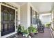 Inviting front porch with rocking chairs, potted plants, and a welcoming entrance with black door at 203 Pathwood Ln, Durham, NC 27705
