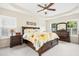 Spacious main bedroom featuring a tray ceiling, ceiling fan, dark wood furniture, and plenty of natural light at 203 Pathwood Ln, Durham, NC 27705