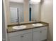 Bathroom with double sink, granite countertops, large mirrors, and white cabinets at 206 E Silver Belle Dr, Zebulon, NC 27597