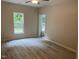 Spacious bedroom features wood-look flooring, ceiling fan, and bright natural light from the windows at 206 E Silver Belle Dr, Zebulon, NC 27597