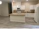 Bright kitchen featuring an island, white cabinetry, stainless appliances, and granite countertops at 206 E Silver Belle Dr, Zebulon, NC 27597
