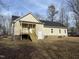 View of back exterior with a wooden deck and stairs leading to the yard at 206 E Silver Belle Dr, Zebulon, NC 27597