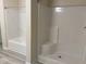The tub and shower combination features white walls and a chrome shower head at 206 E Silver Belle Dr, Zebulon, NC 27597