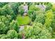 Aerial view of the house with a spacious backyard, mature trees, and outdoor living space at 218 Inwood Forest Dr, Raleigh, NC 27603