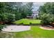 Large backyard with sports court and paver patio featuring an outdoor kitchen and firepit at 218 Inwood Forest Dr, Raleigh, NC 27603