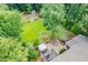 Overhead view of the backyard with fire pit, seating, mature trees, and lush lawn at 218 Inwood Forest Dr, Raleigh, NC 27603