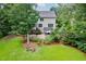 Beautifully landscaped backyard with a stone patio, outdoor seating, and mature trees for shade and privacy at 218 Inwood Forest Dr, Raleigh, NC 27603