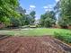Large backyard featuring grass, a fence, and mature trees at 218 Inwood Forest Dr, Raleigh, NC 27603