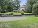 Spacious backyard featuring a tennis court, screened porch, and stone retaining walls at 218 Inwood Forest Dr, Raleigh, NC 27603