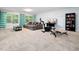 Spacious carpeted basement with comfortable seating area and exercise equipment, perfect for relaxation and fitness at 218 Inwood Forest Dr, Raleigh, NC 27603