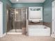Bathroom with shower and large soaking tub under a window at 218 Inwood Forest Dr, Raleigh, NC 27603