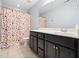 Bright bathroom with a polka dot shower curtain, a dark vanity and tile flooring at 218 Inwood Forest Dr, Raleigh, NC 27603