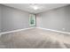 Spacious bedroom featuring plush carpet, ceiling fan, and natural light from a window at 218 Inwood Forest Dr, Raleigh, NC 27603