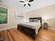 Spacious bedroom with hardwood floors, fan, and large bed at 218 Inwood Forest Dr, Raleigh, NC 27603