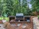 Outdoor kitchen featuring built-in grill and stone-covered counter space at 218 Inwood Forest Dr, Raleigh, NC 27603