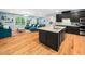 Open-concept kitchen features a large island, black cabinets, and stainless steel appliances at 218 Inwood Forest Dr, Raleigh, NC 27603