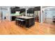 Kitchen with black cabinets, a large island with seating and stainless steel refrigerator at 218 Inwood Forest Dr, Raleigh, NC 27603