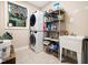 Laundry room with stacked washer and dryer, utility sink, and storage shelves at 218 Inwood Forest Dr, Raleigh, NC 27603
