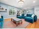 Living room area with hardwood floors, a blue sectional sofa, and blue walls at 218 Inwood Forest Dr, Raleigh, NC 27603