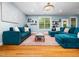 Bright living room with hardwood floors, blue walls, and two blue sectional sofas at 218 Inwood Forest Dr, Raleigh, NC 27603