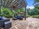 Inviting patio with stone flooring, pergola with ceiling fan, outdoor furniture and spa covered by pergola at 218 Inwood Forest Dr, Raleigh, NC 27603