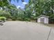 Private backyard tennis court with storage shed surrounded by mature landscaping at 218 Inwood Forest Dr, Raleigh, NC 27603