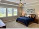 Inviting bedroom featuring large windows, a ceiling fan, a plush carpet, and a comfortable bed at 223 Chauncey Cir, Chapel Hill, NC 27516