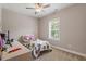 Neutral bedroom with a large window, ceiling fan, twin bed with soccer-themed bedding, and a desk at 223 Chauncey Cir, Chapel Hill, NC 27516