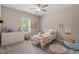 Cozy bedroom with a ceiling fan, bright window, floral bedspread, and a soft rug at 223 Chauncey Cir, Chapel Hill, NC 27516