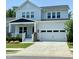 Charming two-story home with a covered front porch, white siding, and a two-car garage on a sunny day at 223 Chauncey Cir, Chapel Hill, NC 27516