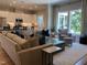 Inviting living room featuring a comfortable couch, accent pillows, large windows, and an open view of the kitchen at 223 Chauncey Cir, Chapel Hill, NC 27516