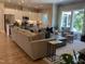 Inviting living room featuring a comfortable couch, accent pillows, large windows, and an open view of the kitchen at 223 Chauncey Cir, Chapel Hill, NC 27516