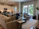 Inviting living room featuring a comfortable couch, accent pillows, large windows, and an open view of the kitchen at 223 Chauncey Cir, Chapel Hill, NC 27516