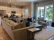 Inviting living room featuring a comfortable couch, accent pillows, large windows, and an open view of the kitchen at 223 Chauncey Cir, Chapel Hill, NC 27516