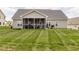 A well maintained backyard showing the lawn, patio, and screened-in porch at 2413 Whelen Dr, Graham, NC 27253