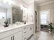 Bright bathroom with double vanity, white cabinetry, tile floors, and a glass-enclosed shower with tile surround at 2413 Whelen Dr, Graham, NC 27253