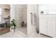 Bathroom featuring a glass door shower, tile surround, plants and a cabinet with adjacent walk-in closet at 2413 Whelen Dr, Graham, NC 27253
