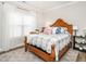 Bright bedroom with a wooden frame bed, floral patterned quilt, large window, and a neutral colored rug at 2413 Whelen Dr, Graham, NC 27253